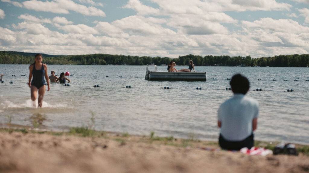 Characters sit by the lake in the film Sunfish