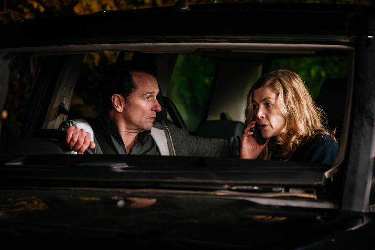 Rosamund Pike and Matthew Rhys sitting in a dark car in the movie Hallow Road