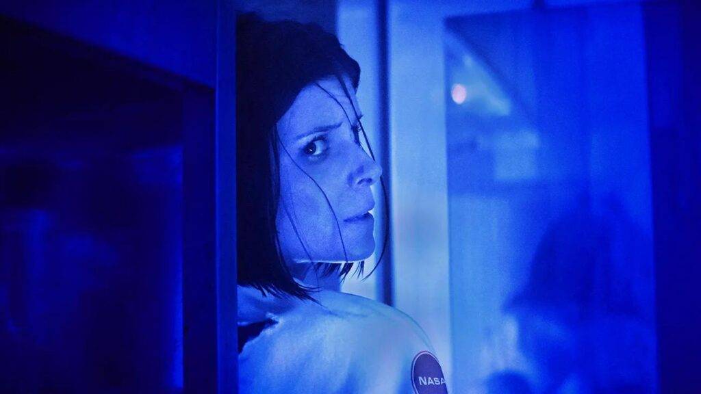 Kate Mara in a blue saturated blue image as an astronaut in fear in the movie The Astronaut