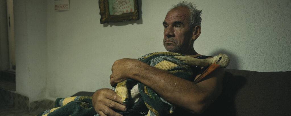 The Tale of Silyan Still - Nikola holding Silyan, wrapped in a blanket in the living room. (Credit: Ciconia Film/Jean Dakar)