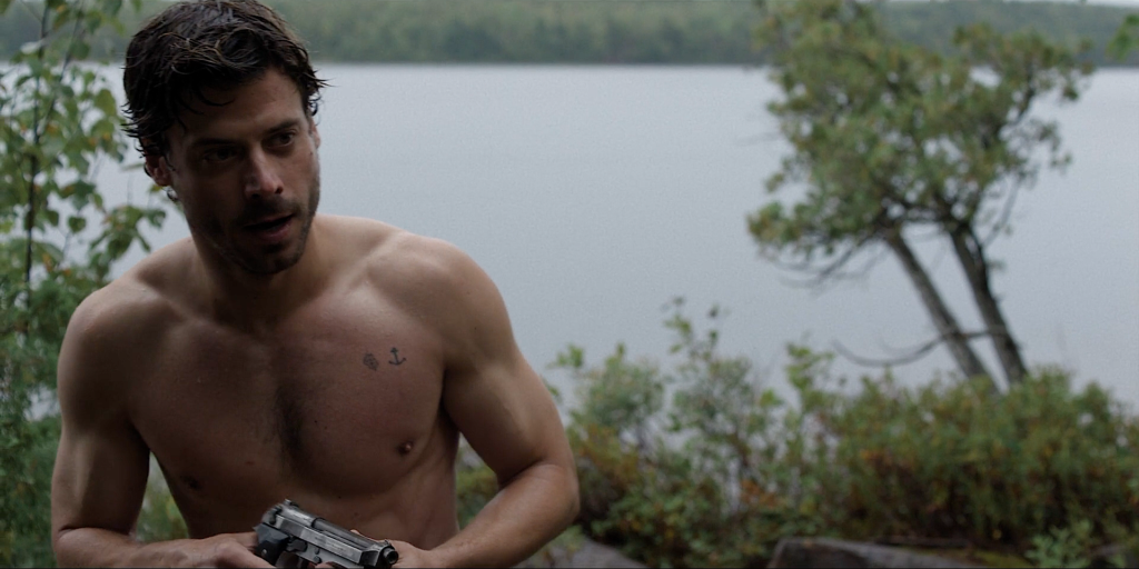 A shirtless François Arnaud stands in front of a lake in the film Someone's Daughter
