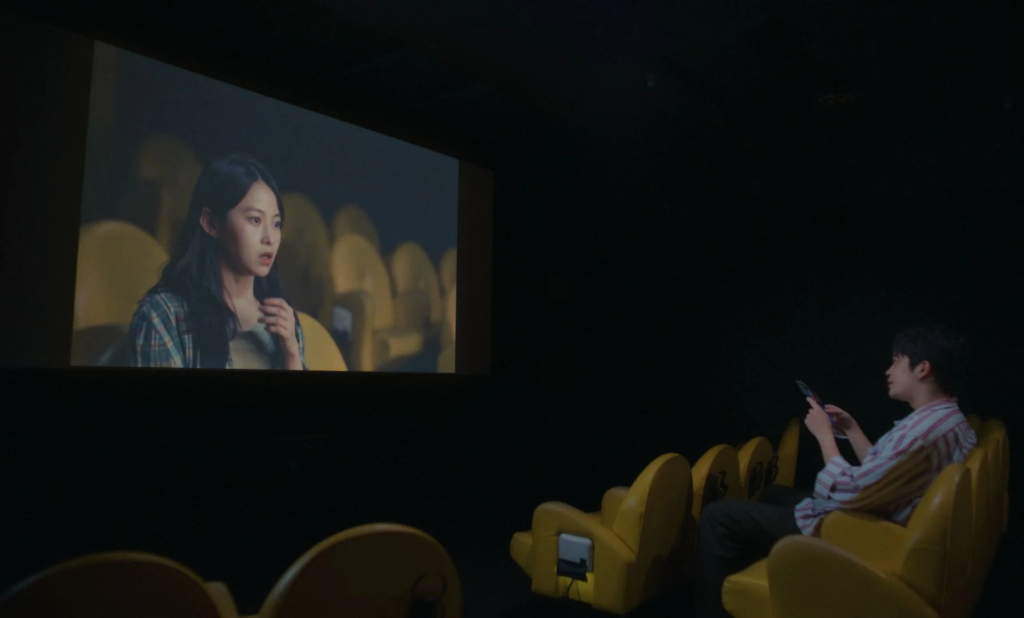 Man watching a woman on a cinema screen in You Are the Film