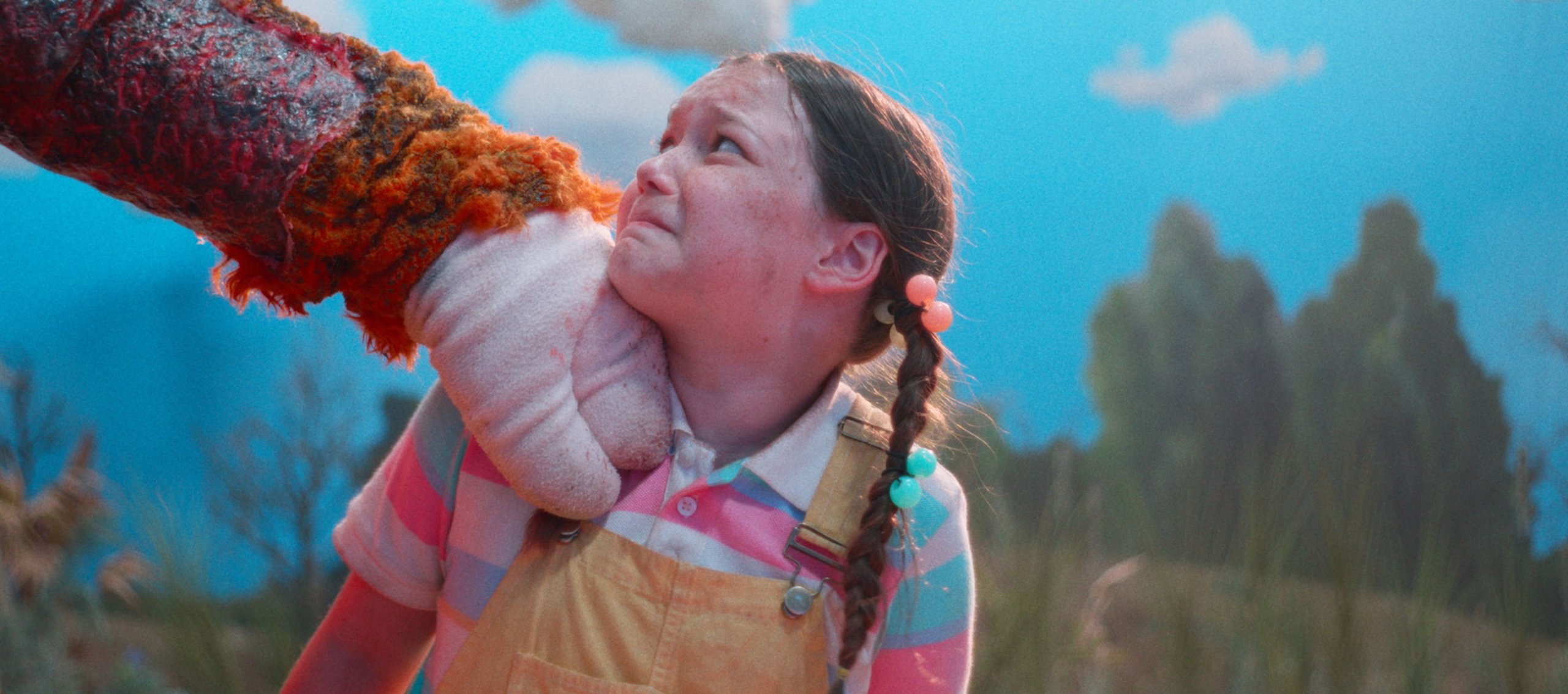 A young girl is terrified, with a mascot's hand resting on her shoulder