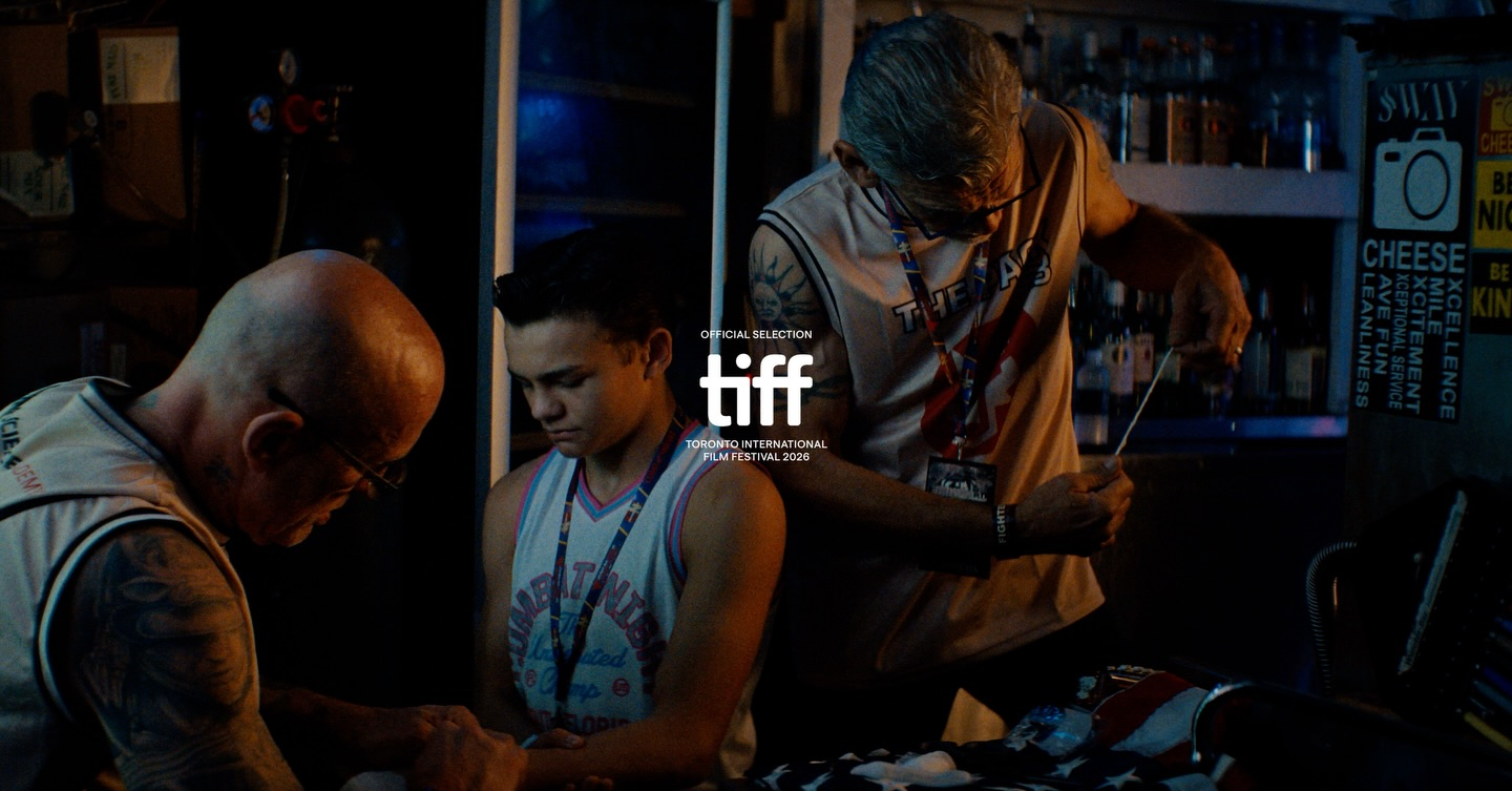 A father, son, and trainer prepare for a big fight in low light